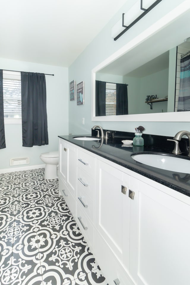 bathroom featuring toilet, vanity, and tile patterned flooring