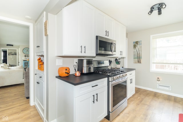 kitchen featuring white cabinetry, stainless steel appliances, and light hardwood / wood-style flooring