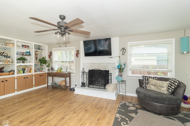 living room featuring light wood-type flooring, plenty of natural light, and ceiling fan