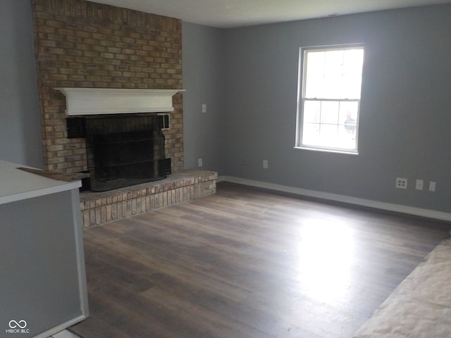 unfurnished living room featuring a fireplace and dark hardwood / wood-style flooring