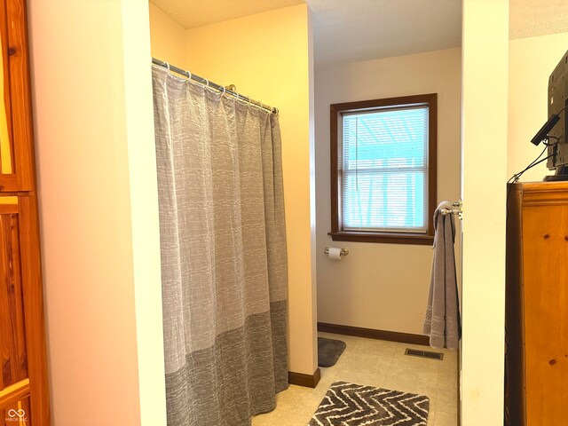 bathroom featuring tile patterned floors and curtained shower