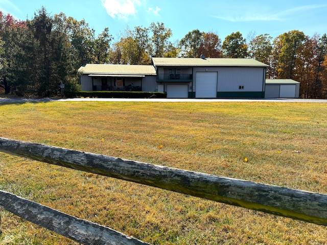 single story home with a garage, a front lawn, and an outdoor structure