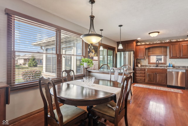 dining area with sink and dark wood-type flooring