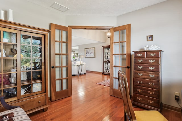 office area featuring french doors, hardwood / wood-style flooring, and a textured ceiling