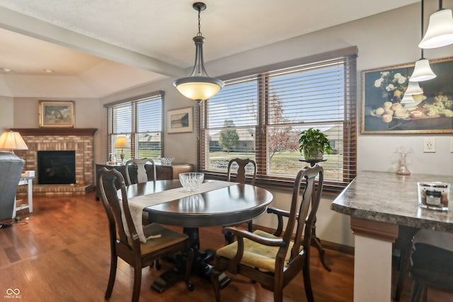 dining room with hardwood / wood-style floors and a fireplace