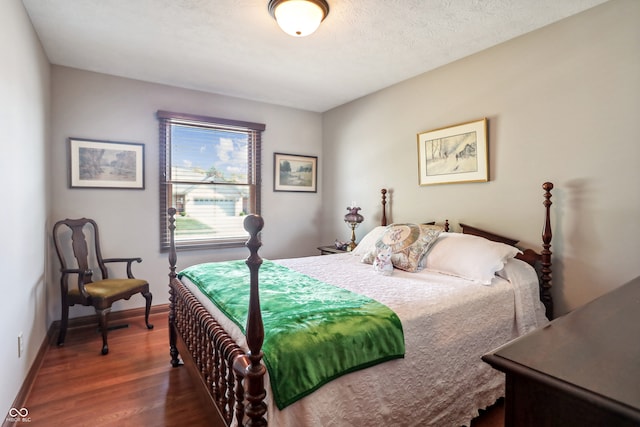 bedroom featuring a textured ceiling and dark hardwood / wood-style flooring