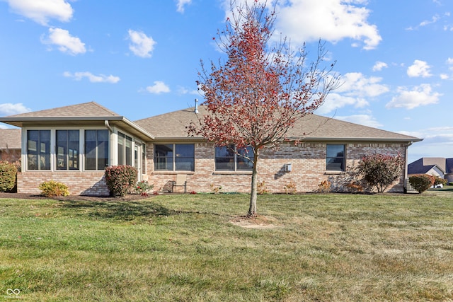 rear view of property with a yard and a sunroom