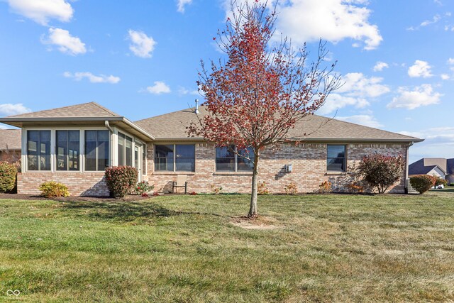 3784 Mansfield Dr, Brownsburg, IN 46112 - rear view of house featuring brick siding, a lawn, a shingled roof, and a sunroom