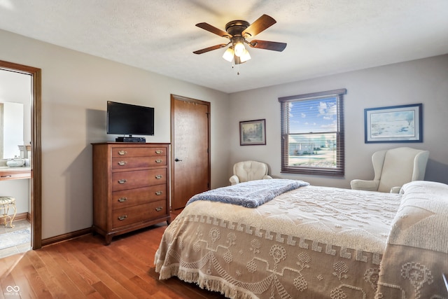 bedroom with hardwood / wood-style floors, a textured ceiling, and ceiling fan