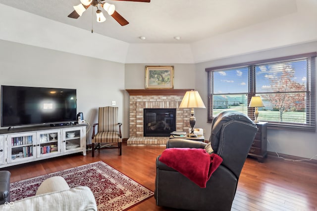 living room with ceiling fan, wood-type flooring, and a fireplace