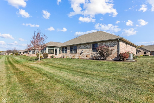 3784 Mansfield Dr, Brownsburg, IN 46112 - back of property featuring brick siding, a yard, central AC unit, and a shingled roof