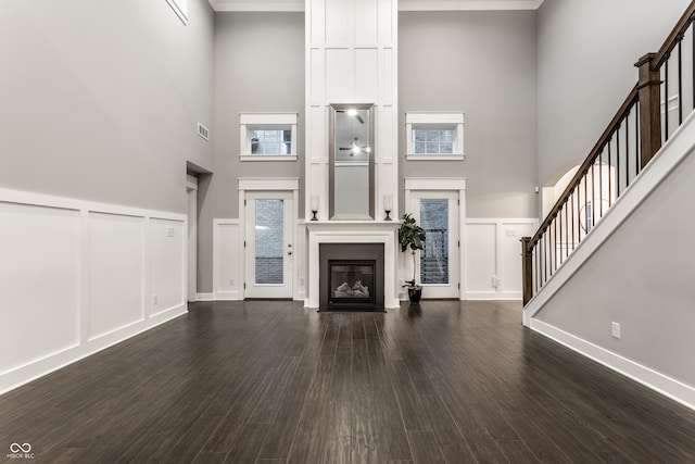 unfurnished living room with a high ceiling and dark hardwood / wood-style flooring