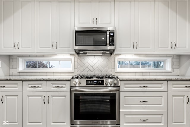 kitchen featuring backsplash, stone counters, white cabinets, and appliances with stainless steel finishes