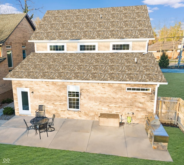 rear view of property with a patio area, exterior kitchen, and an outdoor fire pit