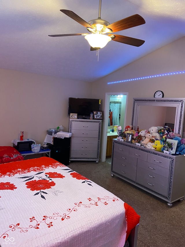 carpeted bedroom with connected bathroom, vaulted ceiling, and ceiling fan