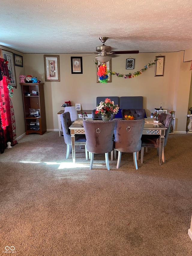 dining room with a textured ceiling, carpet floors, and ceiling fan