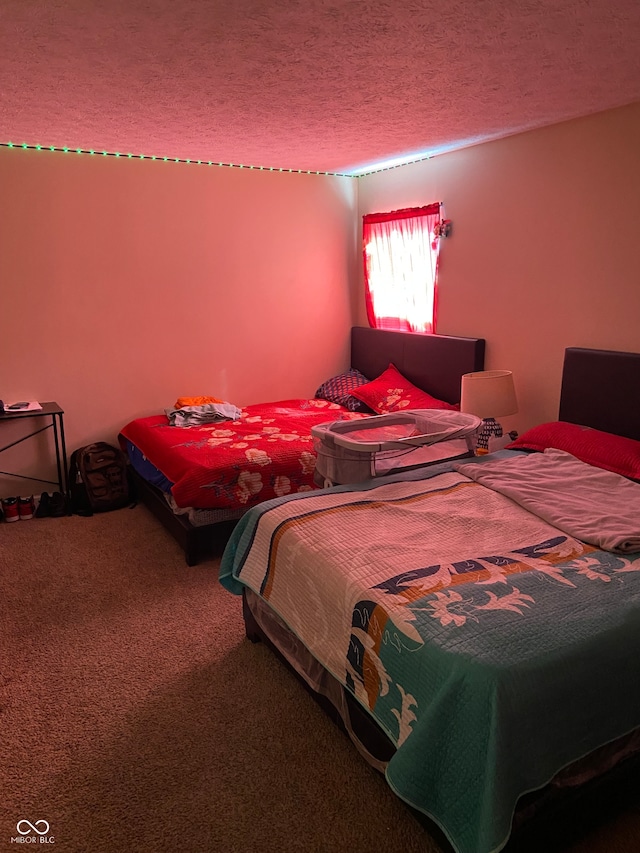 bedroom featuring a textured ceiling and carpet flooring