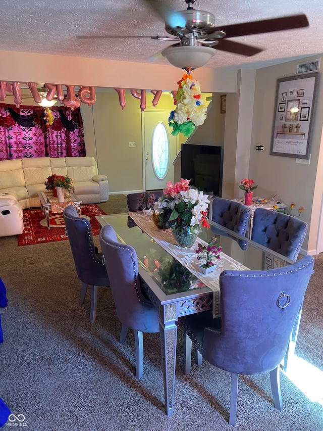 dining room featuring a textured ceiling, carpet, and ceiling fan