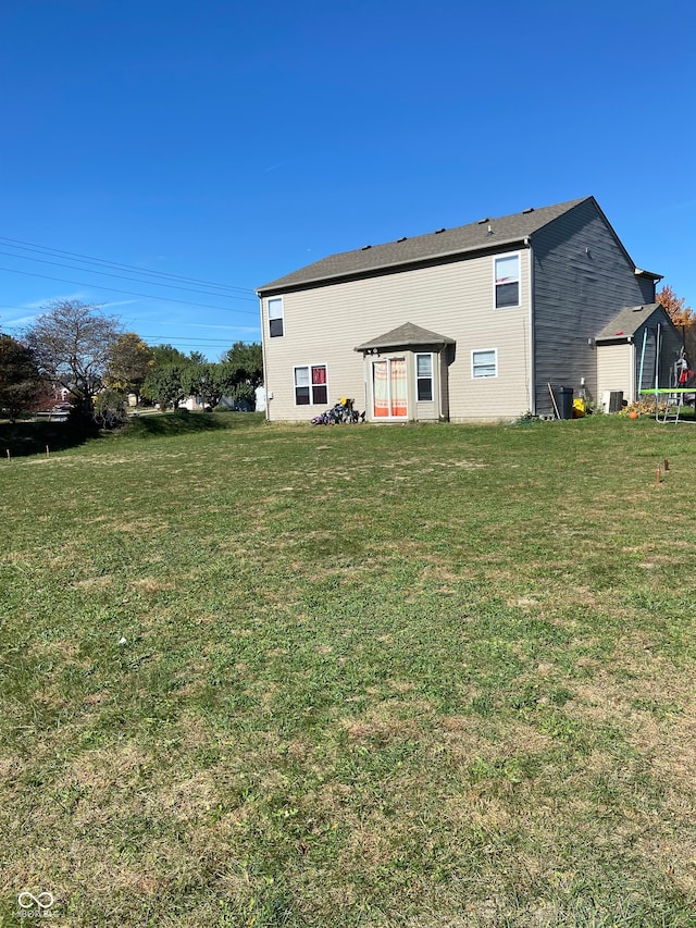 rear view of house featuring a yard and central AC