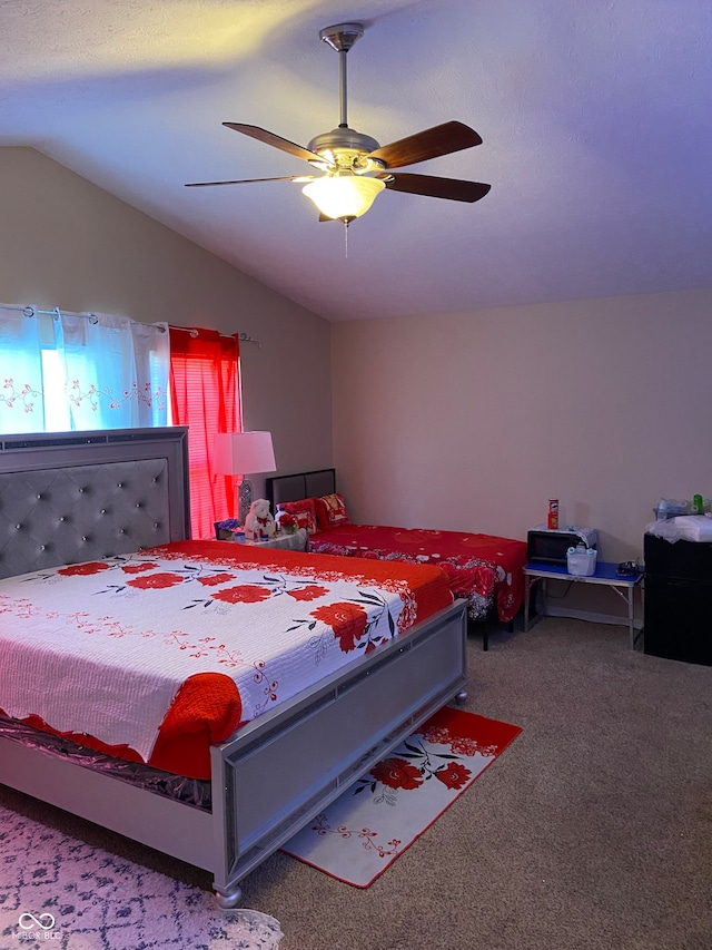 carpeted bedroom featuring lofted ceiling and ceiling fan