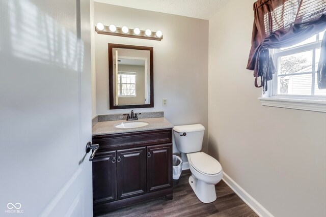 bathroom with vanity, toilet, a textured ceiling, and hardwood / wood-style floors