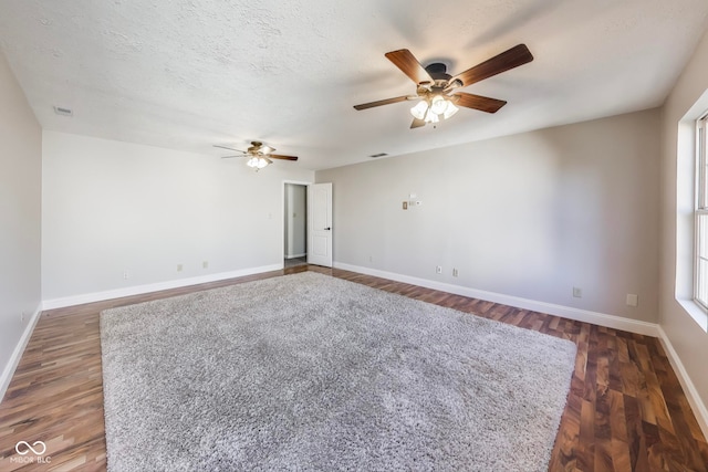 spare room with dark wood-type flooring, a textured ceiling, and ceiling fan