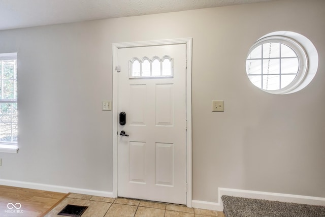 entryway featuring a textured ceiling and light tile patterned floors