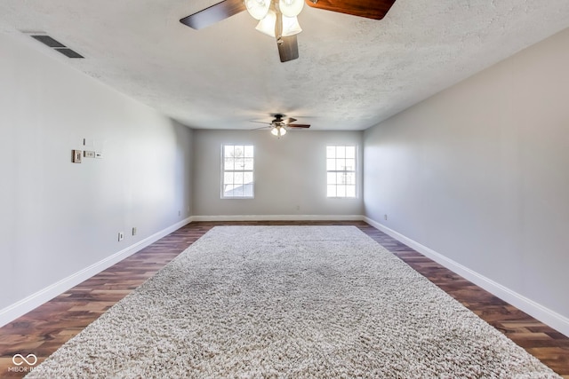 spare room with dark wood-type flooring, ceiling fan, and a textured ceiling