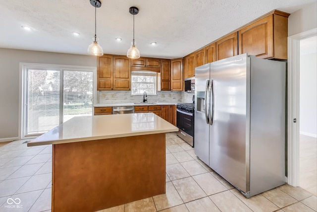 kitchen featuring sink, a center island, appliances with stainless steel finishes, and a healthy amount of sunlight