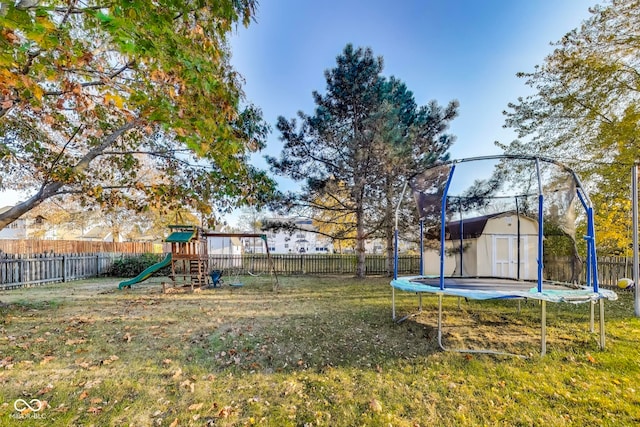 view of yard with a shed, a trampoline, and a playground