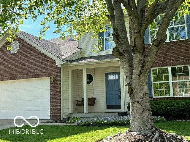 534 Austrian Way, Avon, IN 46123 - entrance to property with brick siding, a porch, an attached garage, and a shingled roof