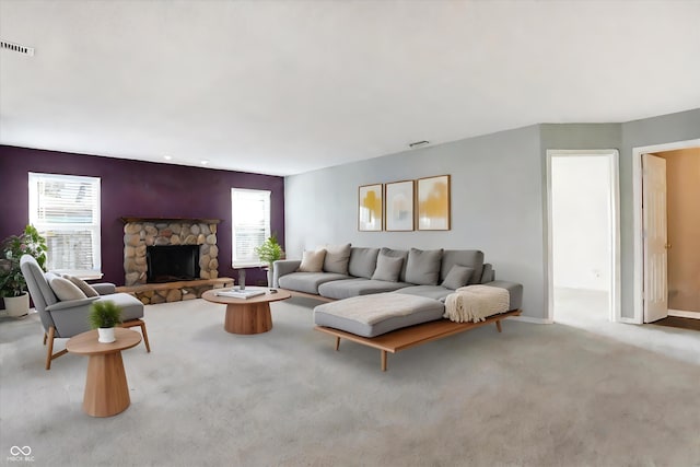 living room with a fireplace, light carpet, and plenty of natural light