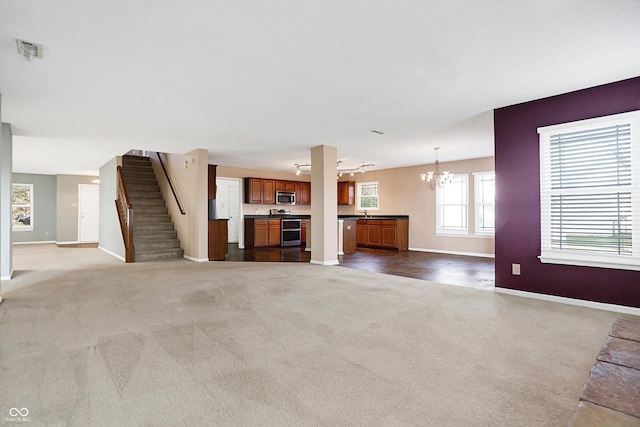 unfurnished living room with a chandelier and carpet floors