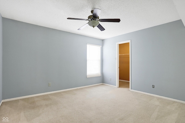 unfurnished room featuring a textured ceiling, ceiling fan, and light carpet