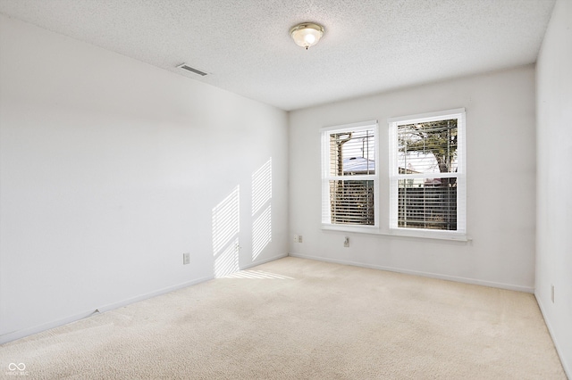 carpeted empty room with a textured ceiling