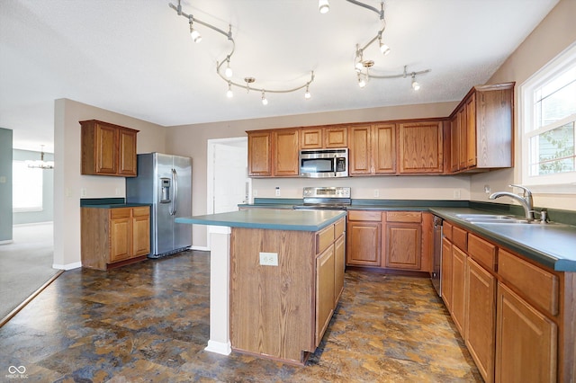 kitchen with appliances with stainless steel finishes, a center island, a notable chandelier, and sink