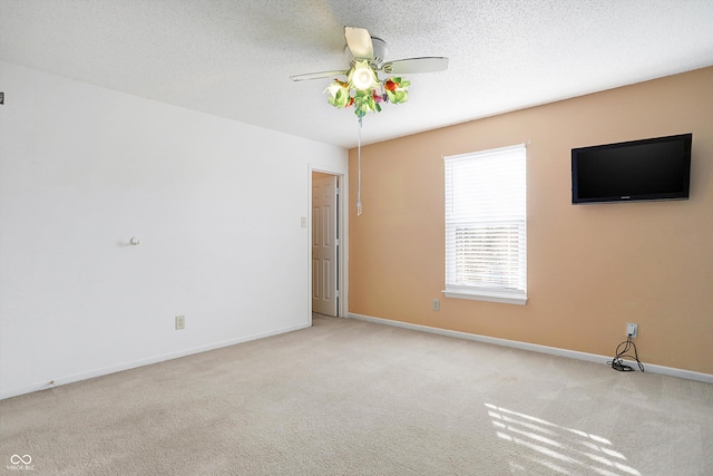 carpeted empty room with a textured ceiling and ceiling fan