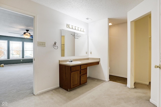 bathroom with ceiling fan, vanity, a textured ceiling, and toilet