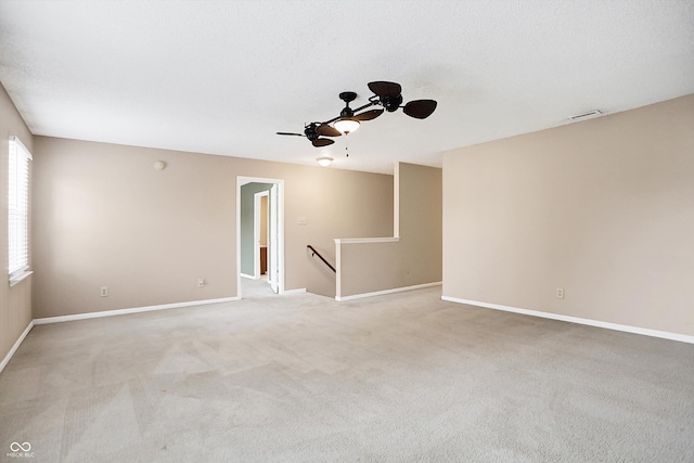 carpeted spare room with ceiling fan