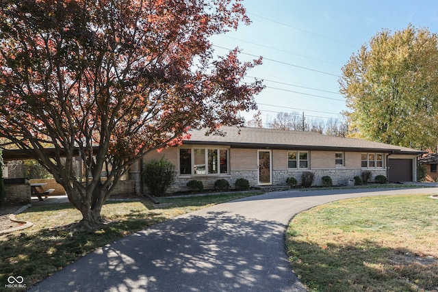 ranch-style home featuring a front yard and a garage