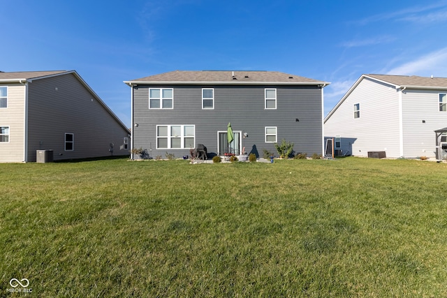 rear view of property featuring central air condition unit and a lawn