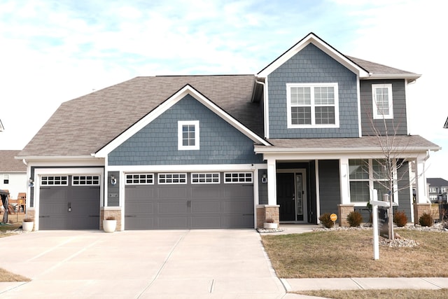 craftsman inspired home featuring a garage, covered porch, and a front lawn