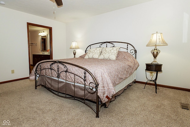 carpeted bedroom with ensuite bathroom and ceiling fan