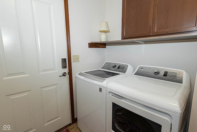 laundry room with separate washer and dryer and cabinets