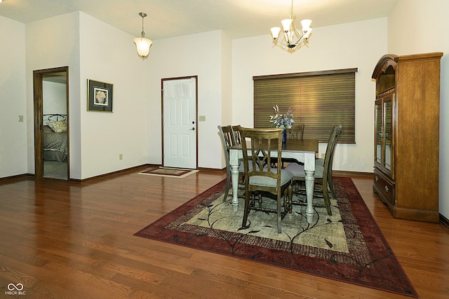 dining space featuring dark wood-type flooring and a notable chandelier