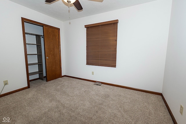 carpeted empty room featuring a textured ceiling and ceiling fan