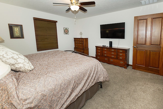 carpeted bedroom with a textured ceiling and ceiling fan