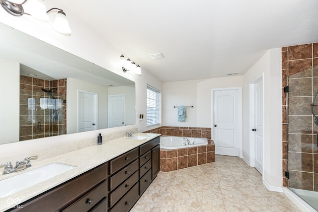 bathroom with vanity and shower with separate bathtub