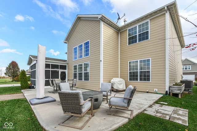 rear view of property with a lawn, a patio area, a sunroom, an outdoor hangout area, and central air condition unit