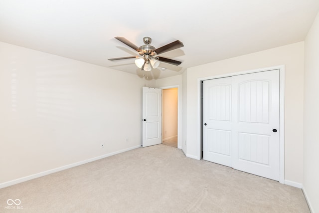 unfurnished bedroom with ceiling fan, light colored carpet, and a closet